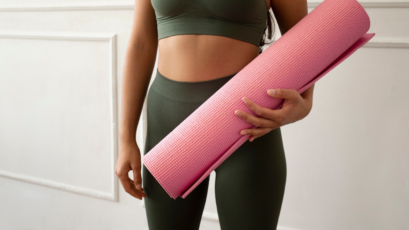 alumna sujetando esterilla de pilates