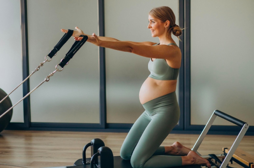 mujer embarazada haciendo pilates maquina